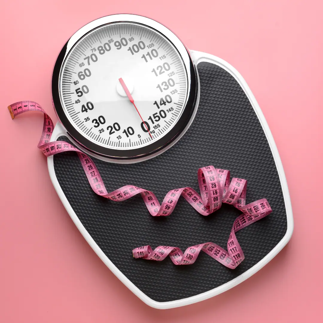 A bathroom scale with a pink measuring tape